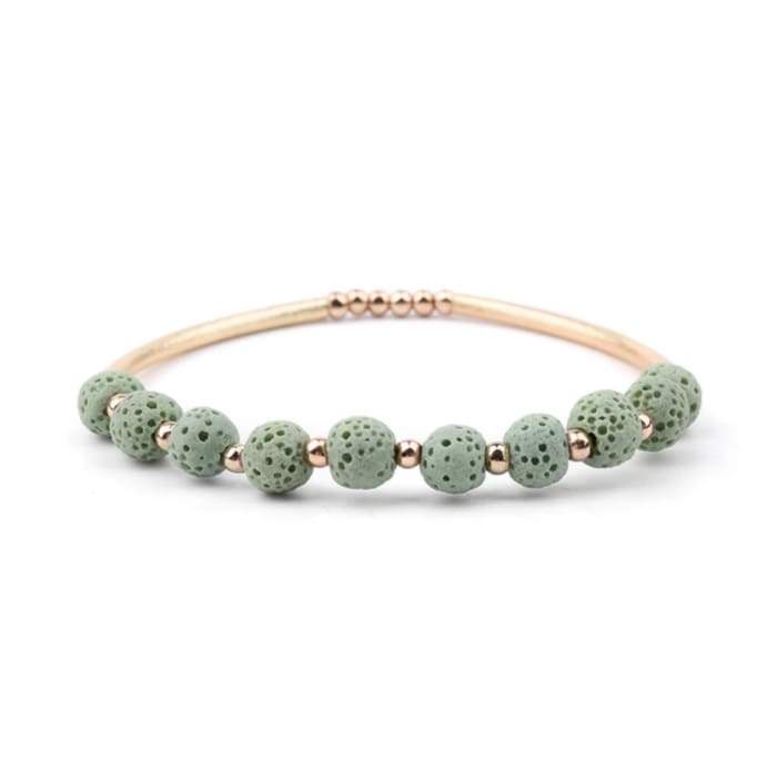 Bracelet with green beads and rose gold accents on a white background